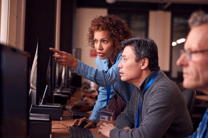 Black woman and Asian man working at a computer