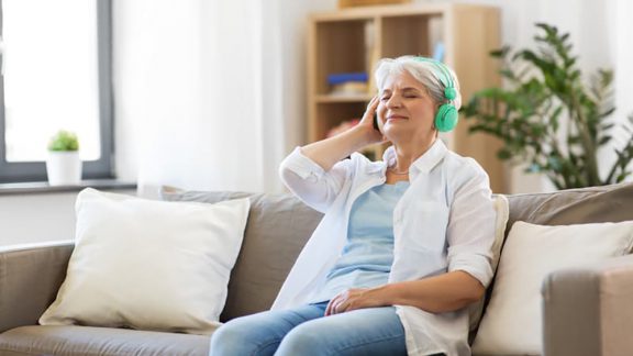 Senior woman listening to a podcast