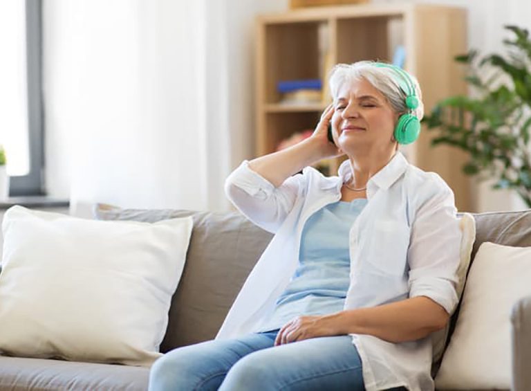 Senior woman listening to a podcast