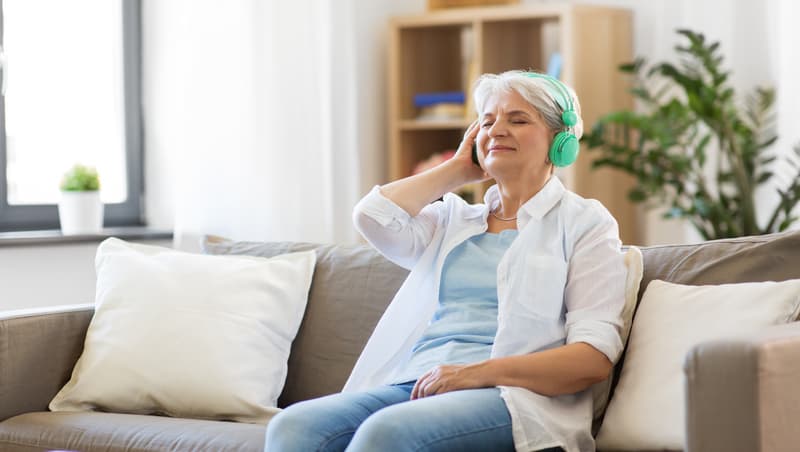 senior woman listening to a podcast, for article, Podcasting to benefit senior service businesses