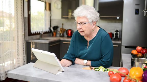 Senior looking at tablet computer for article