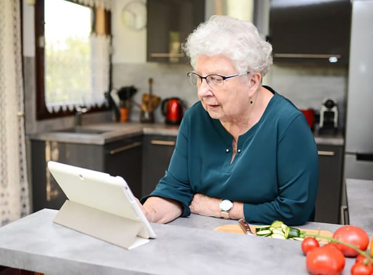 Senior looking at tablet computer for article