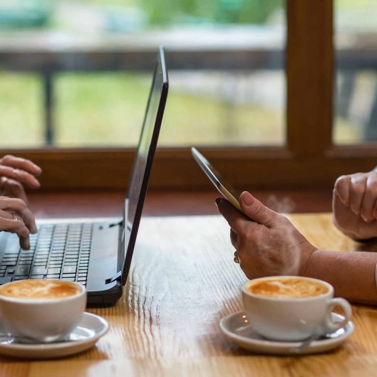 Seniors drinking coffee while on devices