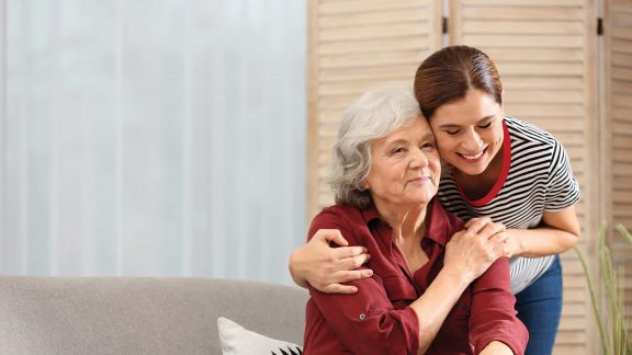 Senior woman with adult daughter embracing