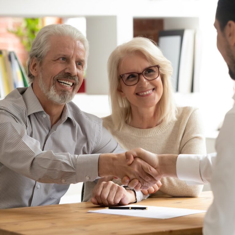 senior couple shaking hands with insurance salesman. By Fizkes. Case study on Medicare lead generation